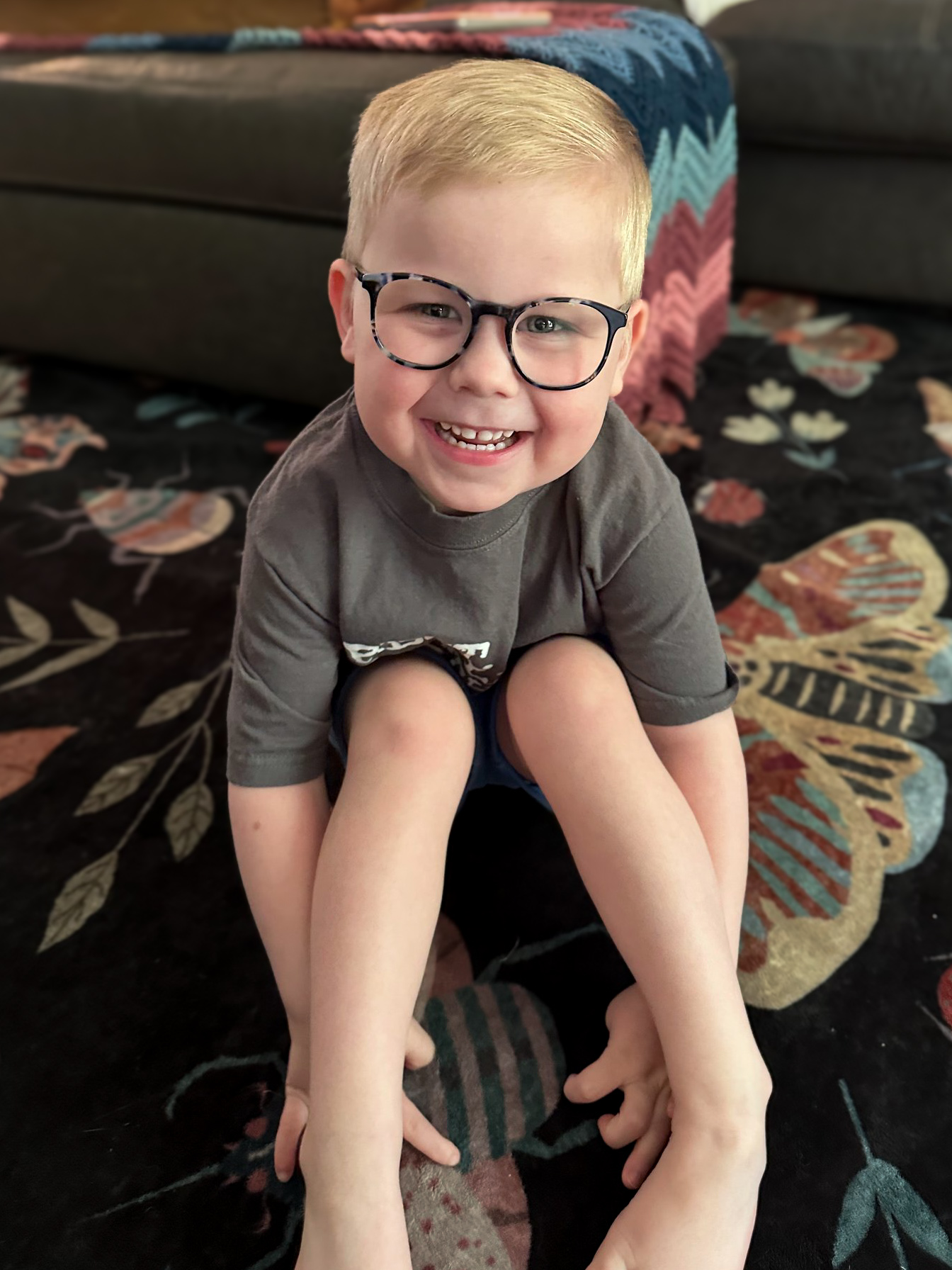 Felix, a joyful four-year-old in tortoiseshell glasses, beaming at the camera